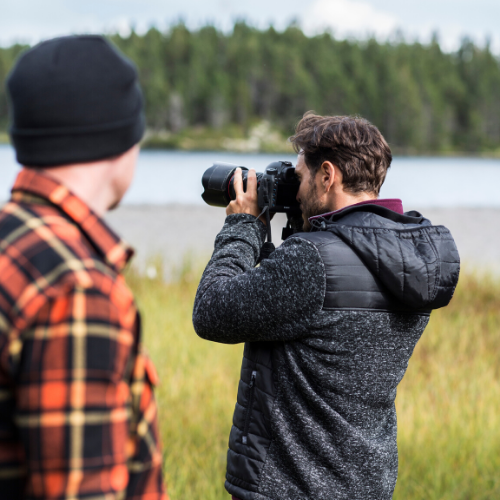 Un homme prend une photo d'un paysage en pleine nature